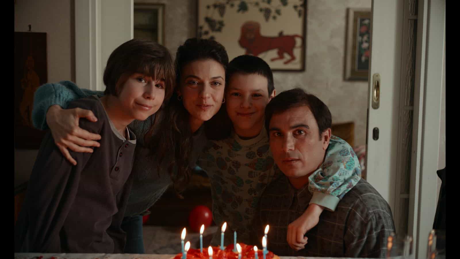 Família reunida diante de bolo em cena de Família, entre filmes sobre pai