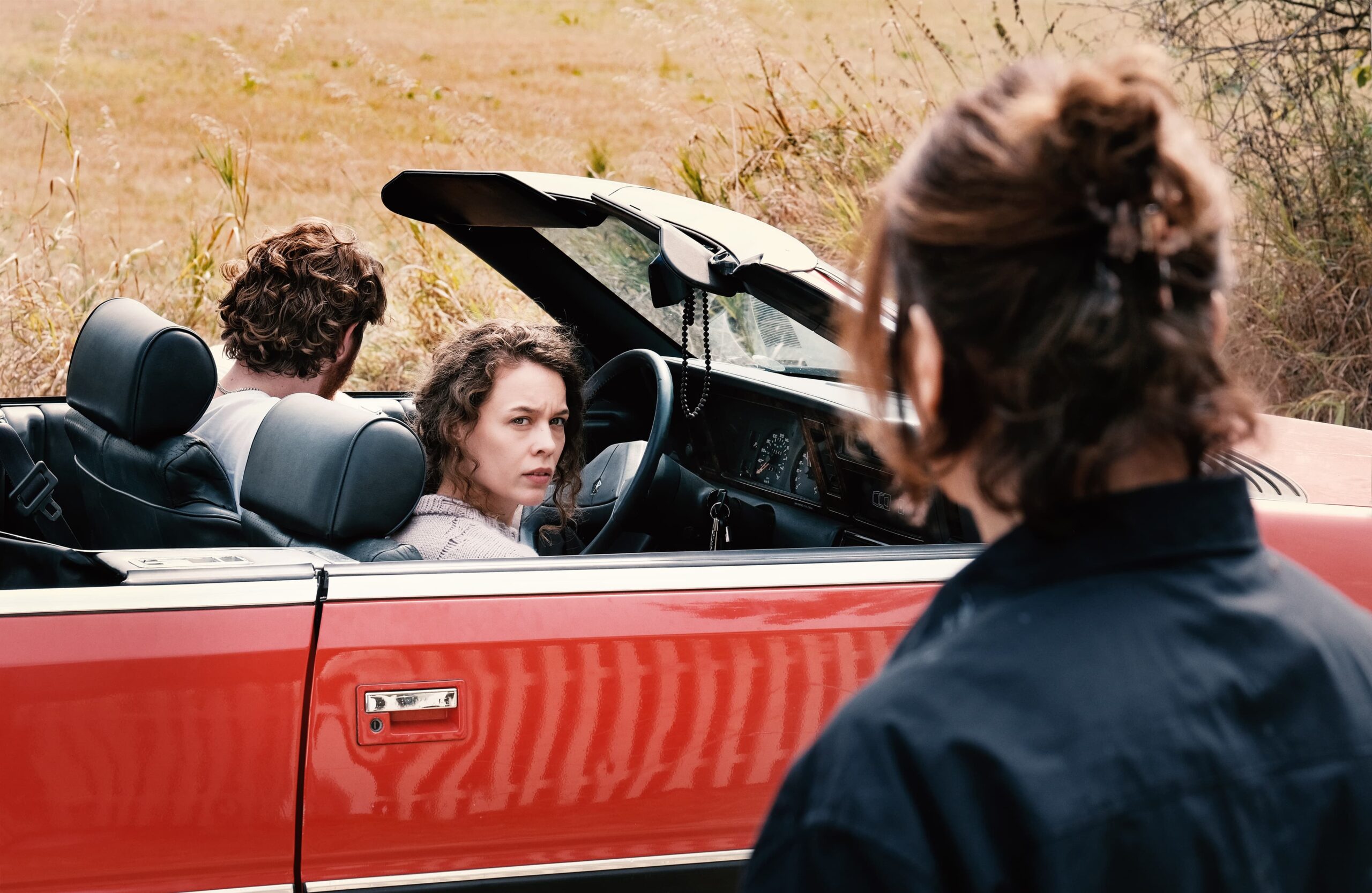 Laura observa Betty ao lado de carro conversível em cena de Mirrors No. 3