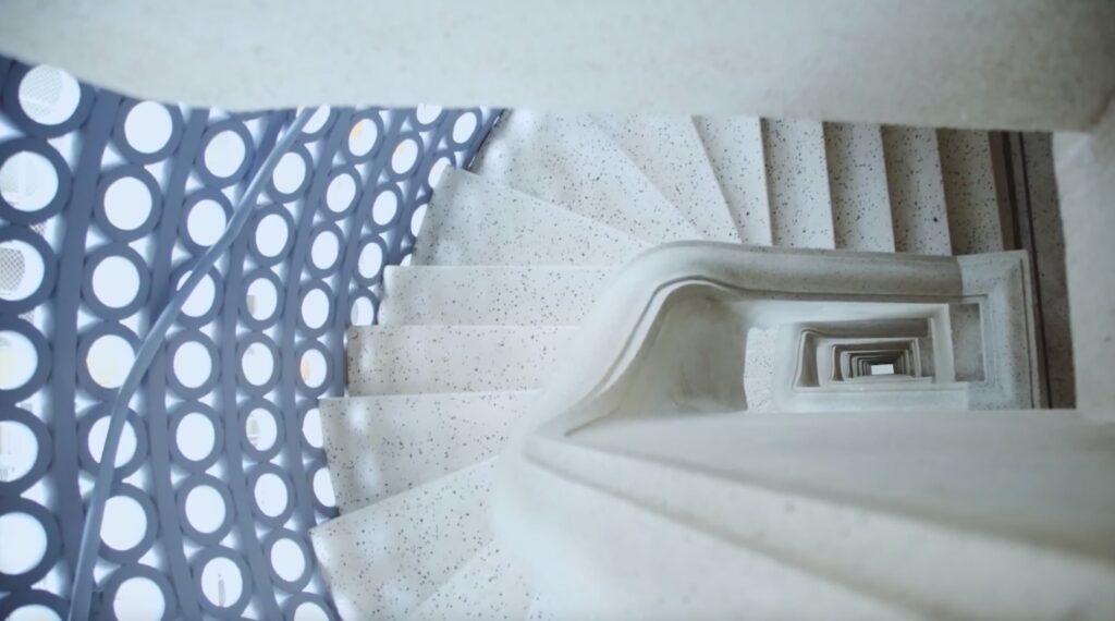 Escada em espiral com guarda-corpo geométrico em edifício projetado por Artacho Jurado