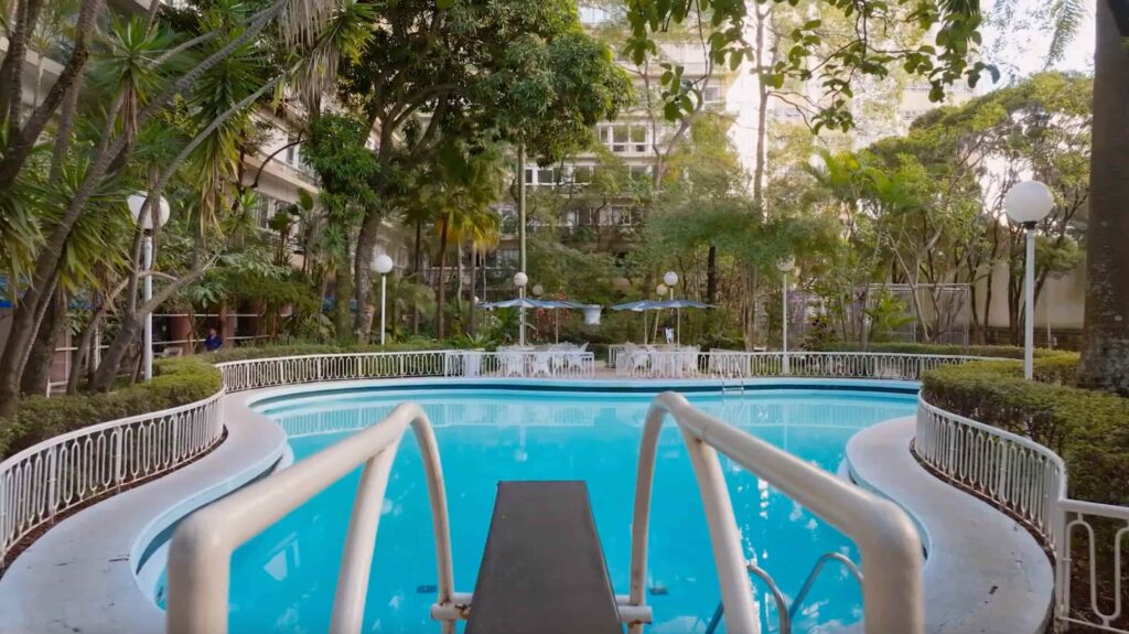 Piscina cercada por jardins em área de convivência de edifício projetado por Artacho Jurado
