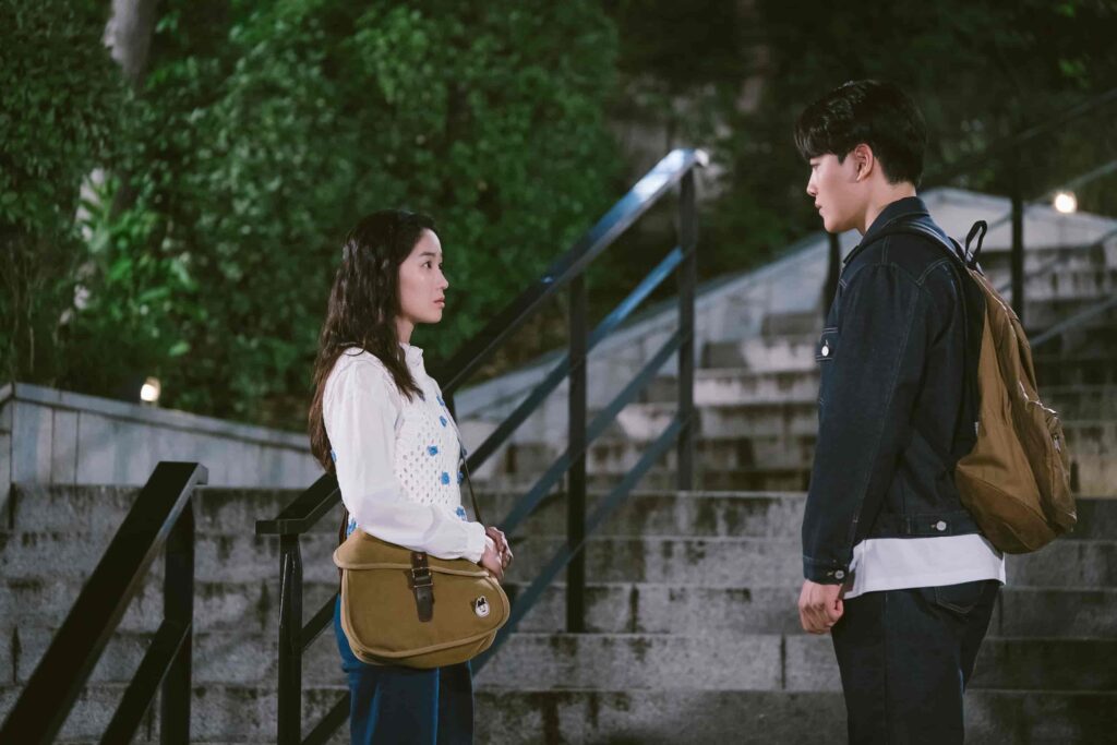 Kim Yong e Kim Mu-nee conversam diante de uma escadaria em cena de Ditto: Conexões do Amor